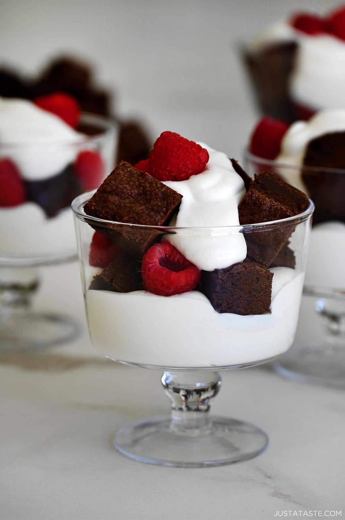 Mini brownie trifles with layers of brownie pieces, juicy raspberries and whipped cream.