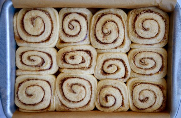 Top down view of unbaked cinnamon rolls in baking dish