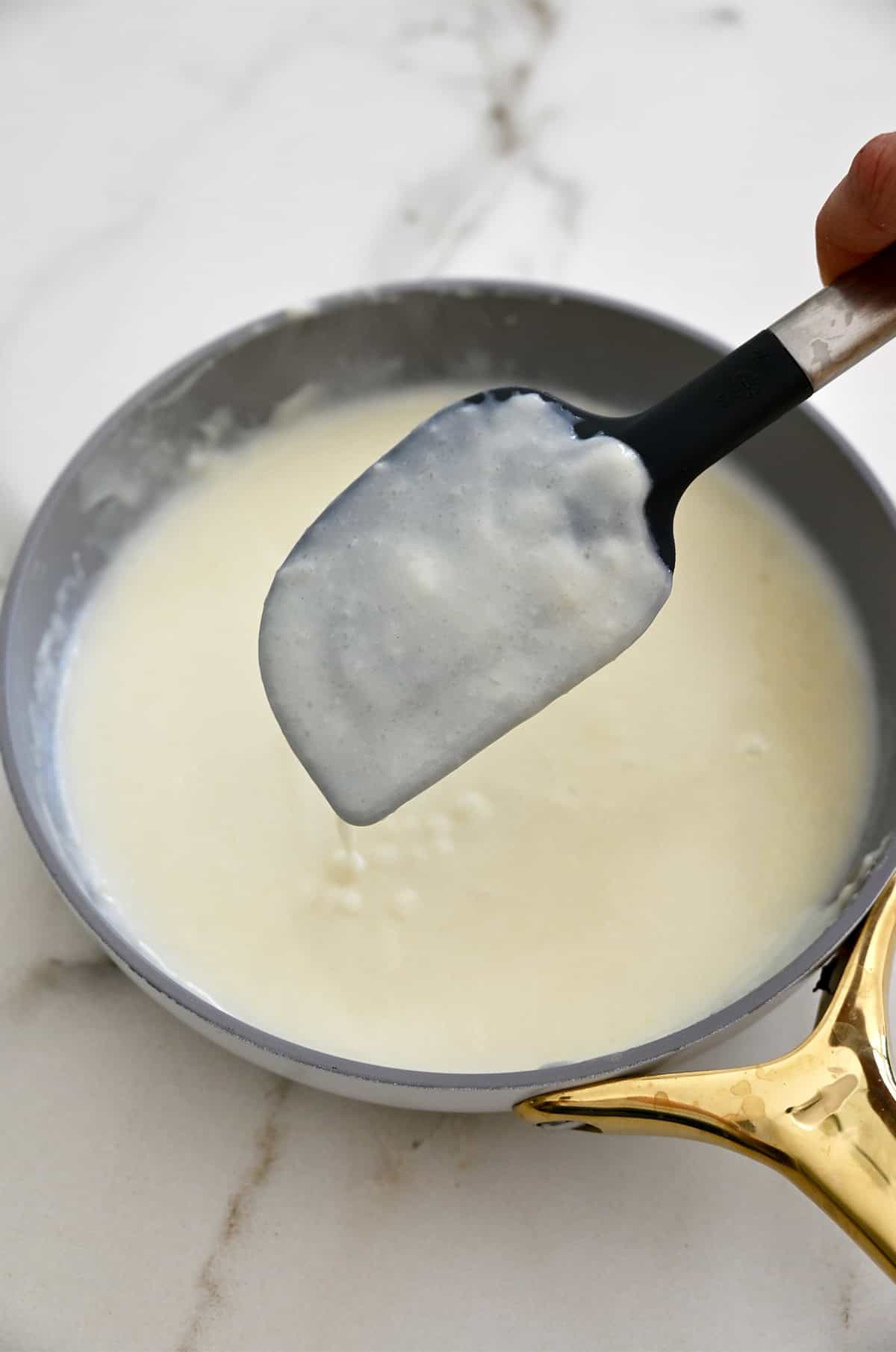 A thickened roux coating a spatula.