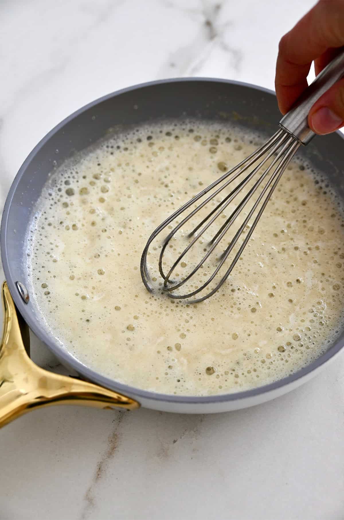 Making a roux from equal parts melted butter and flour in a saucepan.